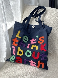 Deep blue canvas tote bag with colorful 3D embroidery and magnetic closure