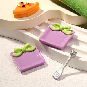 Miniature dollhouse set featuring purple gift bags, a pizza slice, and a metal fork