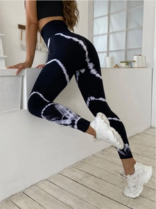 Close-up of high-waisted tie-dye yoga pants showing moisture-wicking fabric and body-shaping fit