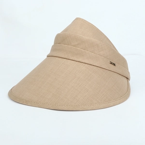 Detailed close-up of khaki sun hat fabric texture with golden metal logo plaque