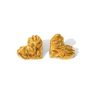 Détail des boucles d'oreilles cœur dorées avec une texture de métal fondu irrégulière