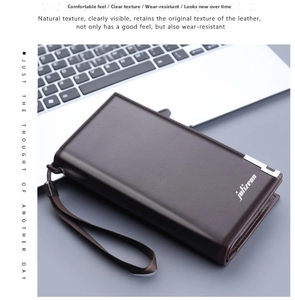 Close-up of deep coffee leather men's long wallet with wrist strap on a laptop background