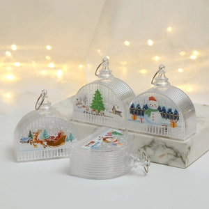 Close-up of transparent Christmas ornaments with festive patterns on marble base