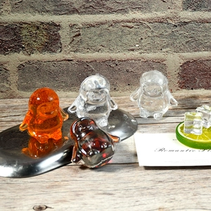 Detail of four colorful penguin-shaped silicone ice molds with a transparent texture