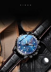 Detail of blue chronograph watch face with black leather strap and red stitching