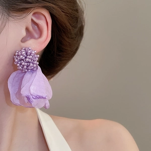 Close-up of elegant purple fabric cluster flower earrings with delicate beaded textures