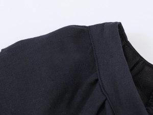 Detail of elegant black puff sleeve dress showing woven fabric texture and stitching
