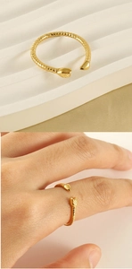 Detail of gold snake ring featuring textured scales and adjustable open design on finger