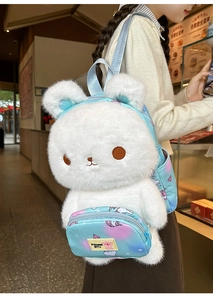Detail of plush white rabbit backpack with blue straps and unicorn pocket storage
