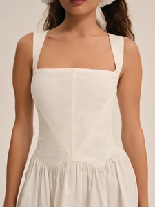Detalle de vestido corto blanco con escote cuadrado, tirantes anchos y talle encorsetado