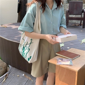 Lifestyle shot of a white canvas tote bag with chamomile print in a cozy outdoor garden