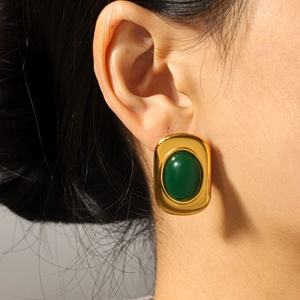 Boucles d'oreilles rétro en or 18k et acier avec pierre verte sur le modèle