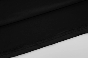 Close-up of the stitching and high-quality black fabric texture on the dress hemline