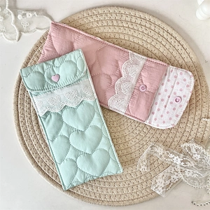 Detailed view of quilted heart pattern pouches with lace trim in mint and pink