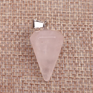 Macro shot of faceted pink crystal dowsing pendulum pendant on a woven burlap texture