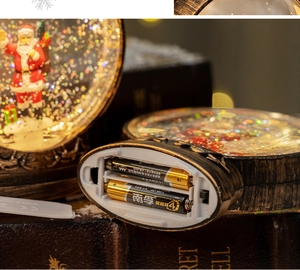 Detail view of the battery compartment and bottom power switch of Santa snow globe lantern