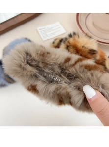 Close-up of fluffy leopard print plush hair claw clip showing soft faux rabbit fur texture