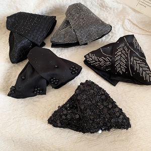 Detailed view of luxury black acrylic claw clips set with rhinestones and pearls on fabric