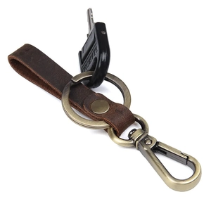 Vintage dark brown leather keychain with bronze metal ring and spring hook on white background