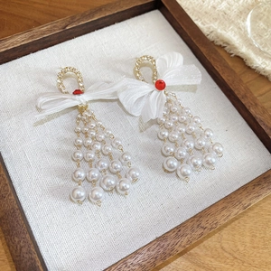 Detail of bow-knot pearl tassel earrings with white lace and sparkling red crystal accents