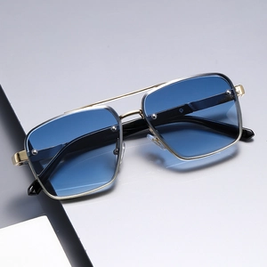 Detalle de gafas de sol ovales de moda con lentes azules degradadas y montura dorada