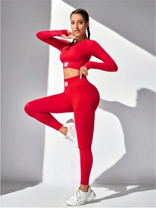 Close-up of red seamless high waist yoga leggings and long sleeve top with GYM WEAR tag