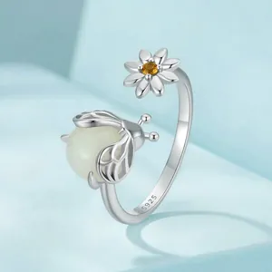 Adjustable S925 sterling silver ring with daisy and glowing beetle in 45-degree view