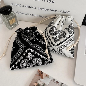 Detail of drawstring pouches with paisley patterns and soft cotton cords in a lifestyle set