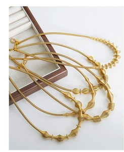 Detail of 18K gold-plated titanium steel necklace with intricate wire-wrapped texture