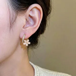 Elegant 18k gold plated flower drop earrings with zircon crystals on a model
