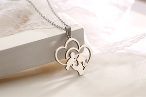 Macro shot of silver heart pendant featuring a mother holding baby silhouette on lace