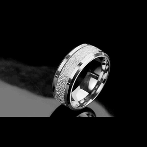 Detail of silver clover ring featuring unique frosted texture and polished beveled edges