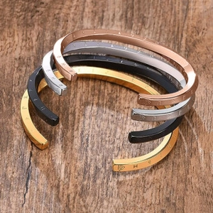 Macro shot of stainless steel bangles with Roman numerals in four metallic colors