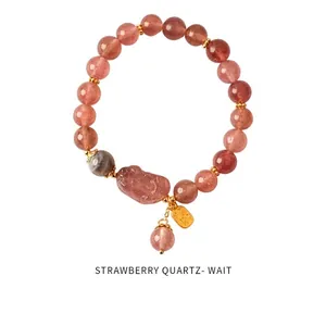 Close-up of pink strawberry quartz beads with golden spacer charms and Pixiu pendant