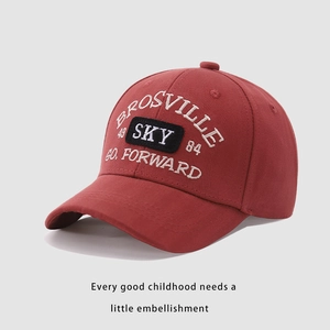 Detailed white embroidery on a brick red cotton baseball cap with SKY patch and BROSVILLE text