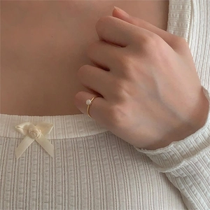Minimalist gold S925 silver ring featuring a single white pearl on a model's hand