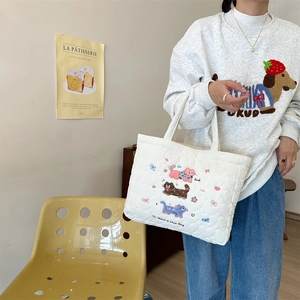 Close-up of white quilted tote bag featuring cute cat embroidery and heart stitching details