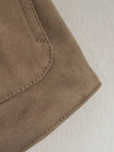 Detail of coffee brown faux suede jacket showing neat stitching and fabric texture