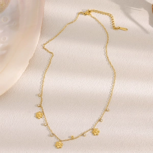 18K gold plated stainless steel flower necklace with zircon crystals on a beige surface