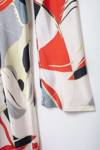 Detail shot of the red and grey geometric abstract patterns on smooth satin fabric