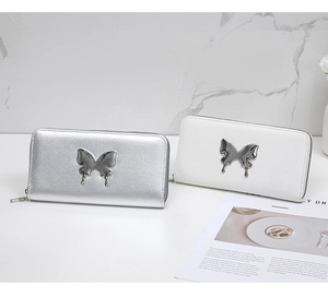 Detail view of long butterfly zip wallets in silver and white faux leather finish