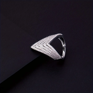 Macro shot of a silver V-shaped ring with pavé-set shimmering zircon stones on a dark base