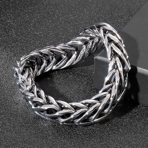 Close-up of a silver V-shaped punk style stainless steel chain bracelet on a black box