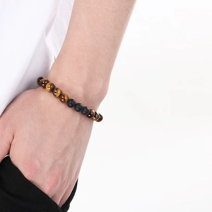Macro view of matte black agate and yellow tiger eye beaded bracelet on wrist