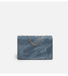 Detailed close-up of blue denim fabric texture and gold chain strap of a square shoulder bag