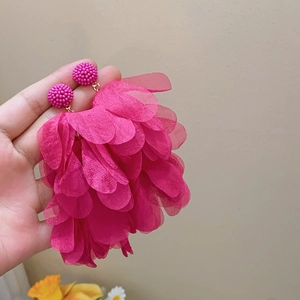 Detail of bright pink fabric flower petal tassel earrings with gold metal studs