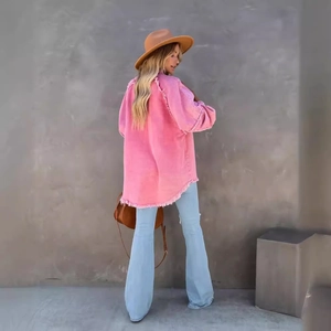 Pink oversized fringe denim jacket with distressed details paired with flare jeans