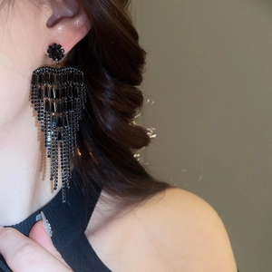 Close-up of black zircon tassel earrings on model for an elegant bohemian evening look