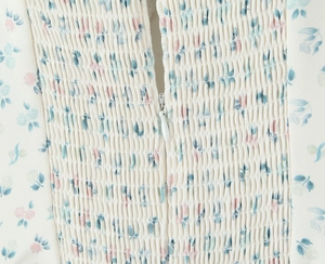 Détail macro du smock élastique sur la robe fleurie avec fermeture éclair invisible