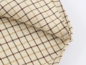 Macro view of plaid pattern fabric with beige texture and quality stitching details